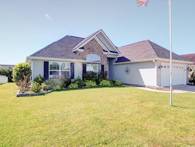 View of front facade with an attached garage, roof with shingles, a front lawn, and driveway
