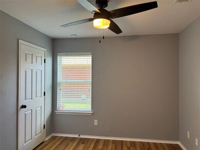 Unfurnished room with ceiling fan, wood-type flooring, and a wealth of natural light
