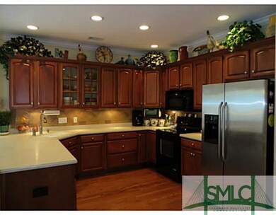 Kitchen. Dark wood cabinets, solid surface counter