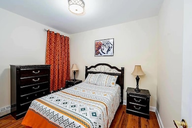 Bedroom with wood finished floors and baseboards