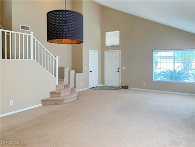 Entryway with high vaulted ceiling, carpet floors,