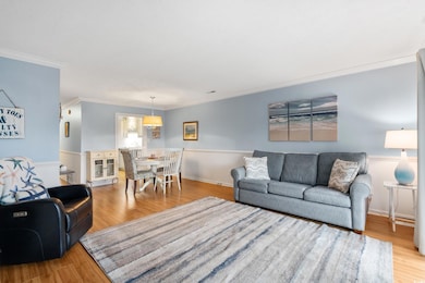 Living area featuring ornamental molding and wood 