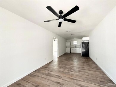 Unfurnished living room featuring ceiling fan and dark wood-type flooring