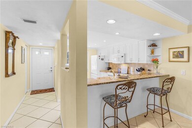 Kitchen featuring kitchen peninsula, light stone c
