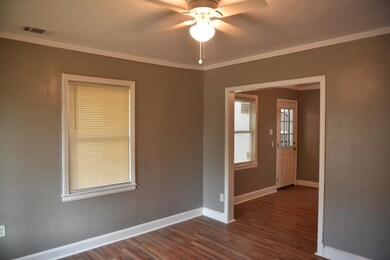 Empty room featuring crown molding, ceiling fan, a