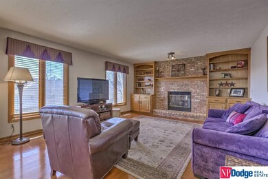 SPACIOUS FAMILY ROOM OPEN TO THE KITCHEN WITH WOODEN FLOORS, FIREPLACE AND BUILT-INS