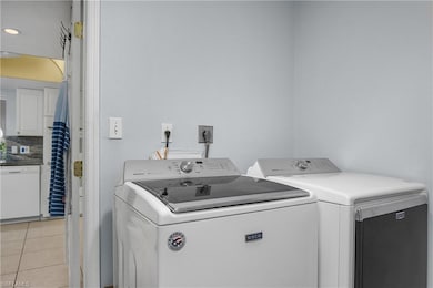 Laundry room with light tile patterned floors and independent washer and dryer