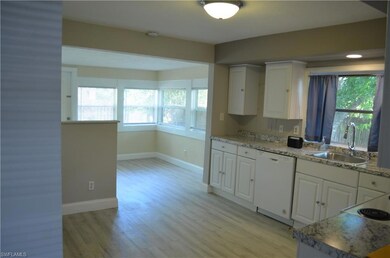 Kitchen featuring light stone countertops, white a