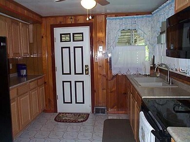 Kitchen. As you enter the kitchen you can see that there is an ample amount of cabinet storage and counter top working area.  The sink has a new faucet that is also a sprayer. and a new ceiling fan.