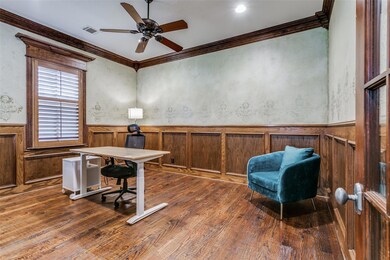 Office space with ceiling fan, crown molding, and dark wood-type flooring