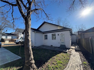 Rear view of house with entry steps and fence