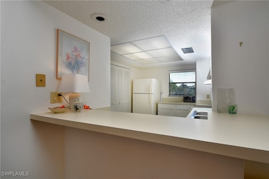 Kitchen featuring kitchen peninsula, sink, and whi