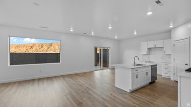 Kitchen featuring an island with sink, white cabinets, dark wood-style floors, light stone counters, and open floor plan