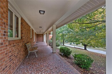 Relax on the front porch. Beautiful trees provide privacy.