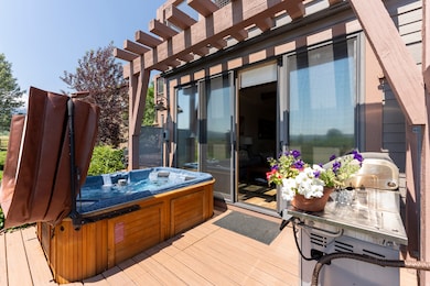 Wooden deck featuring a hot tub and a pergola