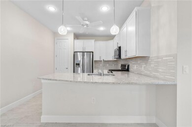 Kitchen featuring light stone counters, a peninsul