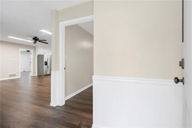 Hall featuring dark wood finished floors, visible vents, and wainscoting