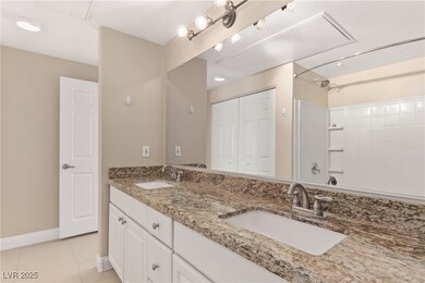 Full bath featuring double vanity, a closet, and light tile patterned floors