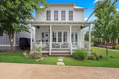 View of front of home featuring a porch, a front lawn, and french doors