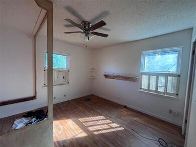 Empty room featuring ceiling fan, a textured ceili