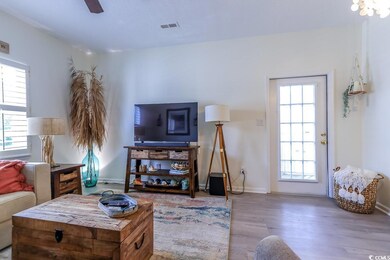 Living room featuring ceiling fan and wood-type fl