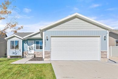 Ranch-style home featuring stone siding, driveway, and a front yard