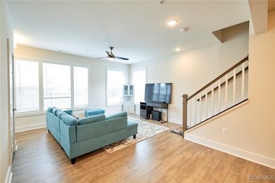 Living room featuring visible vents, a ceiling fan