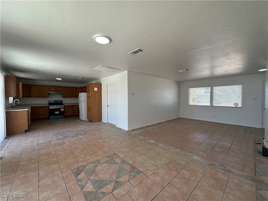 Unfurnished living room with a sink, a textured ce