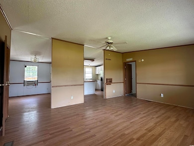 Unfurnished living room featuring a textured ceili