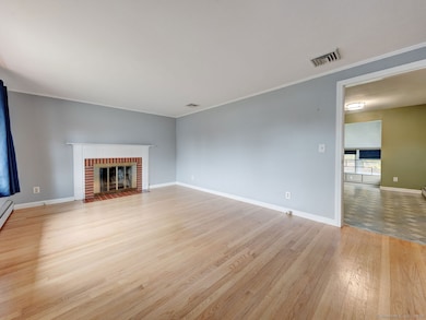 Living room with bay window, wood fireplace and hardwood floor!