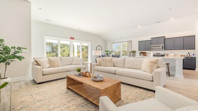Living room with sink, light hardwood / wood-style floors, and lofted ceiling