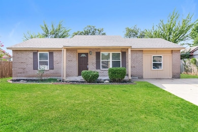 Ranch-style home featuring brick siding, a shingled roof, and covered porch