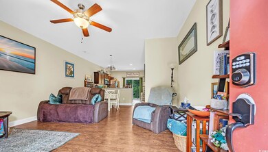 Living area with a ceiling fan, baseboards, wood finished floors, and recessed lighting