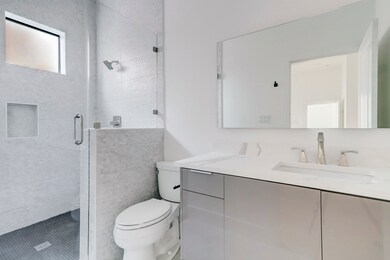 En suite bath with glass enclosed shower and conte