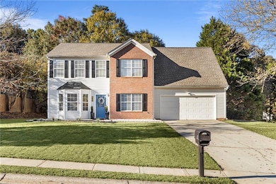 Colonial-style house with driveway, a front lawn, a garage, and a shingled roof
