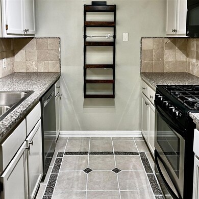 Kitchen with black microwave, baseboards, stainle