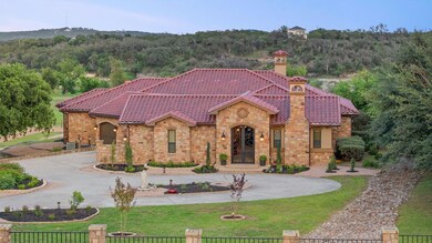 View of front of home with curved driveway, stone