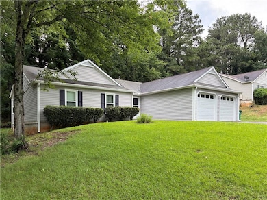 Ranch-style home with a front yard and a garage