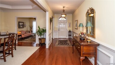 Foyer with wood floors and lots of upgraded moldin