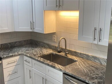 Kitchen with a sink, white cabinets, tasteful backsplash, dishwasher, and dark stone counters