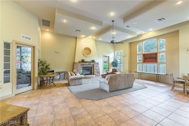 Living room with a towering ceiling, light tile pa