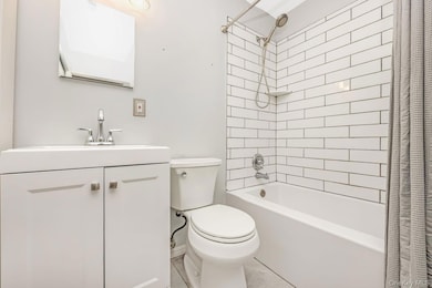 Bathroom featuring shower / bath combo, vanity, and tile patterned flooring