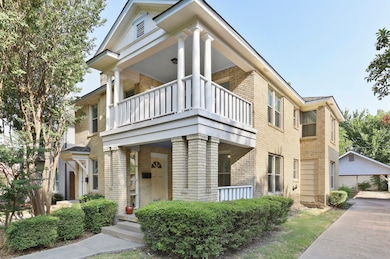 View of front of home featuring brick siding and a balcony