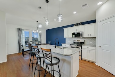 Kitchen with backsplash, light wood-type flooring