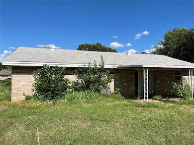 Rear view of property with brick siding and a yard