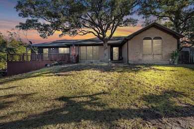 View of front of property featuring brick siding, a front lawn, a deck, and solar panels