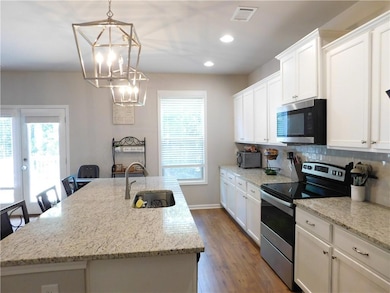 Kitchen featuring stainless steel appliances, plenty of natural light, white cabinets, and recessed lighting