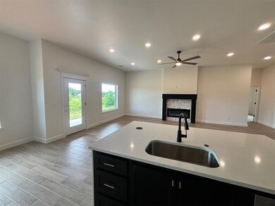 Kitchen featuring a stone fireplace, ceiling fan, 