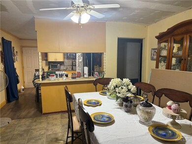 Dining space with a ceiling fan and crown molding