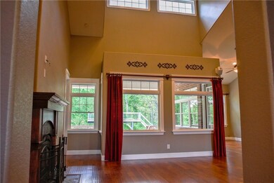 Vaulted ceilings, large windows with views the back yard, and a wood burning fireplace with blower makes the living room feel open, warm, and inviting.